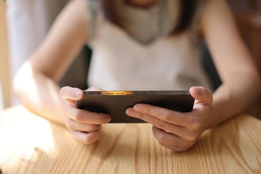 Woman hand using a smartphone for Stock exchange trading online in the coffee shop, business concept