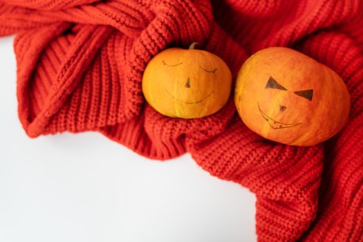 Two pumpkins with a painted face. The concept of the holiday on October 31, Halloween. Place for an inscription