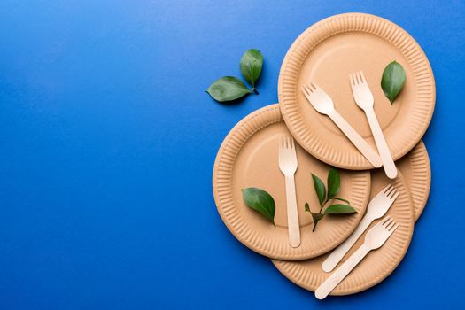 set of empty reusable disposable eco-friendly plates, cups, utensils on light white colored table background. top view. Biodegradable craft dishes. Recycling concept. Close-up.