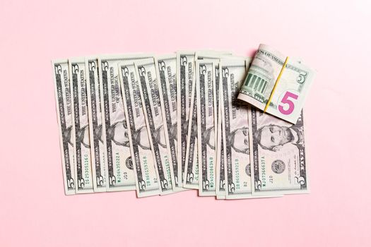 Close up of 5 dollar bills in a row on colorful background. Top view of salary concept.