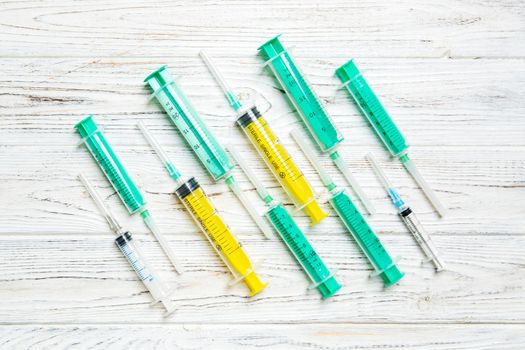 Top view of many syringes prepared for injection at wooden background. Treatment concept with copy space.