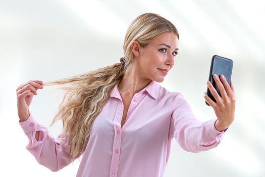 Woman taking a picture of herself by stroking the tip of her hair-Horizontal plane