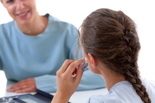 Woman in front of a hearing care professional to test a hearing aid.