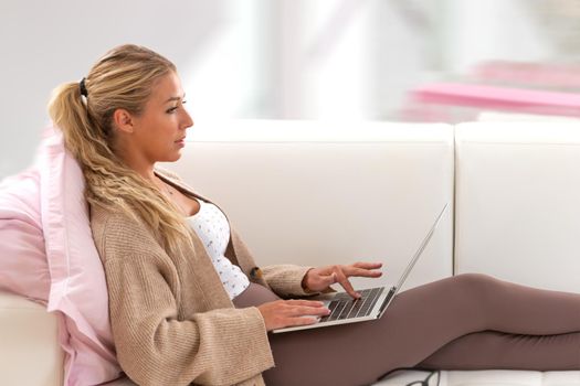 Woman in profile with the laptop on her lap