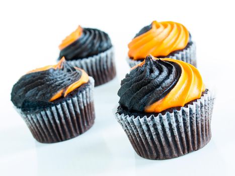 Halloween cupcakes decorated with black and orange swirled icing.