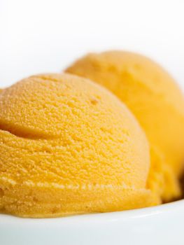 Scoop of gourmet pumpkin gelato in white bowl.