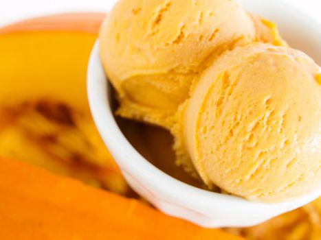 Scoop of gourmet pumpkin gelato in white bowl.