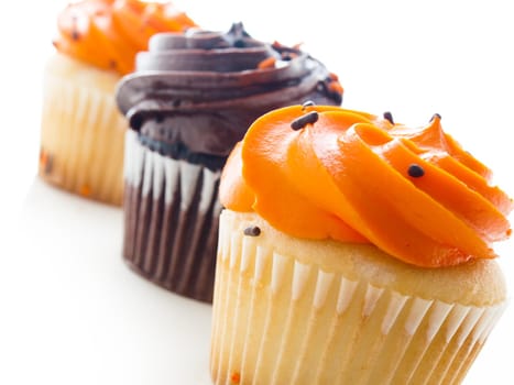 Halloween orange and black cupcakes on white background.