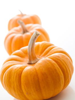 Small orange pumpkins on white background.