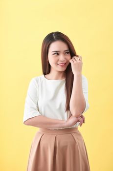 Beauty woman touch her long hair isolated on yellow background, asian beauty 