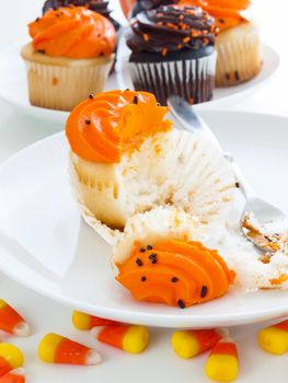 Eating Halloween cupcakes with orange and black icing.