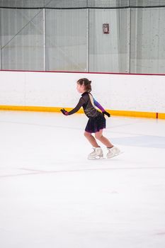 Little girl practicing before her figure skating competition at the indoor ice rink.