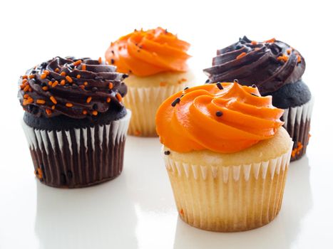 Halloween orange and black cupcakes on white background.