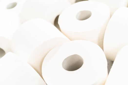 New white toilet paper rolls on a gray background.