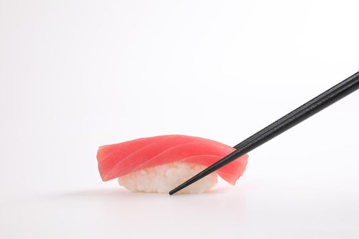 Tuna sushi with chopsticks , Japanese food isolated in white background