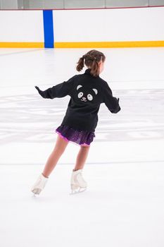 Little girl practicing before her figure skating competition at the indoor ice rink.