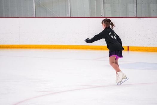 Little girl practicing before her figure skating competition at the indoor ice rink.