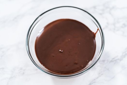 Preparing chocolate ganache in a glass mixing bowl.