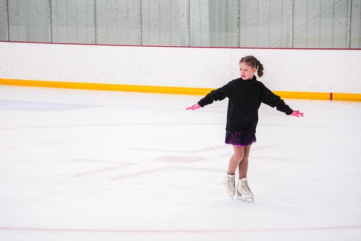 Little girl practicing before her figure skating competition at the indoor ice rink.