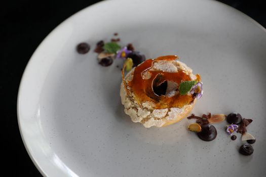 Chocolate dessert cake with berry sauce and almond with decorated