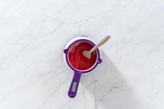 Flat lay. Melting red chocolate chips in a candy melting pot to make chocolate lips and heart shaped chocolates for Valentine's Day.