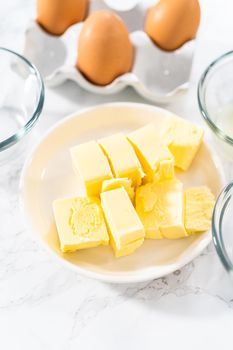 Measured ingredients in glass mixing bowls to prepare hollandaise sauce.