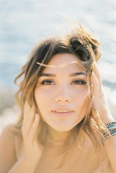 Bride touches her hair with her hands. Portrait. High quality photo