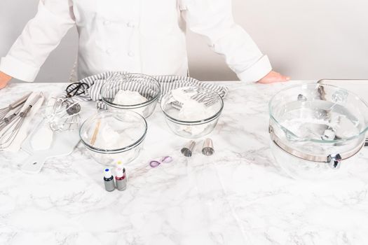 Mixing food coloring into the meringue to bake unicorn meringue cookies.