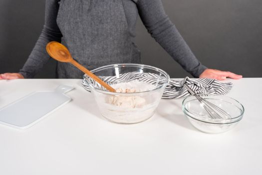 Mixing ingredients in a glass mixing bowl to make homemade flatbread.