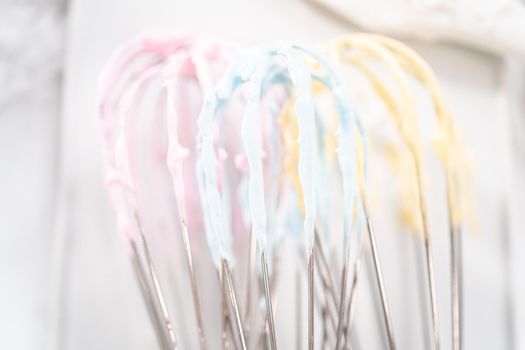 Mixing food coloring into the meringue to bake unicorn meringue cookies.