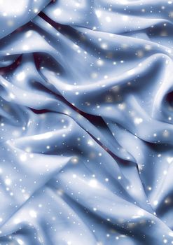 Winter fashion, shiny fabric and glamour style concept - Magic holiday blue soft silk flatlay background texture with glowing snow, luxury beauty abstract backdrop