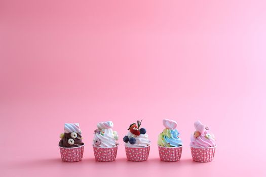 Colorful cupcakes isolated in pink background