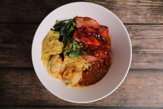 Shrimp dumpling with roasted pork with local thai tom yum spicy sauce on wood background