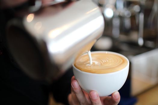 Male hands pouring milk and preparing to making cappuccino coffee