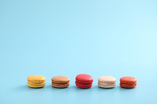 Colorful macarons isolated in blue background