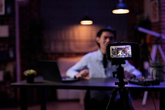 Lifestyle influencer filming video on camera, creating content for social media channel and broadcasting live discussion. Using audio and sound equipment at production station, recording vlog.