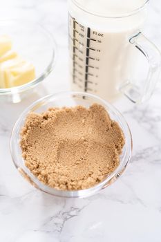 Measured ingredients in a glass mixing bowl to preparetoffee glaze.