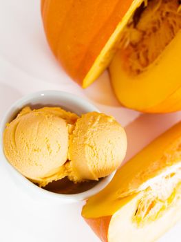 Scoop of gourmet pumpkin gelato in white bowl.
