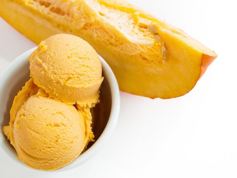 Scoop of gourmet pumpkin gelato in white bowl.