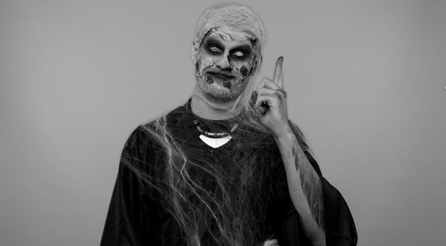 Eureka. Inspired sinister man Halloween crazy zombie with bloody wounded scars face make gesture raises finger came up with creative plan feels excited with good idea, inspiration motivation. Horror