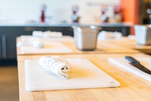 Tables prepared with white cutting boards and aprons for cooking class.