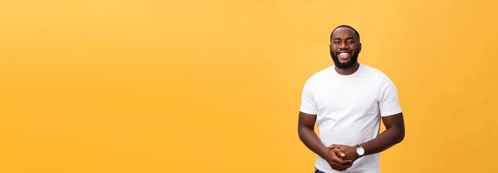 Portrait of delighted African American male with positive smile, white perfect teeth, looks happily at camera, being successful enterpreneur, wears white t shirt