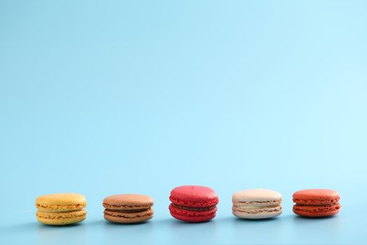 Colorful macarons isolated in blue background