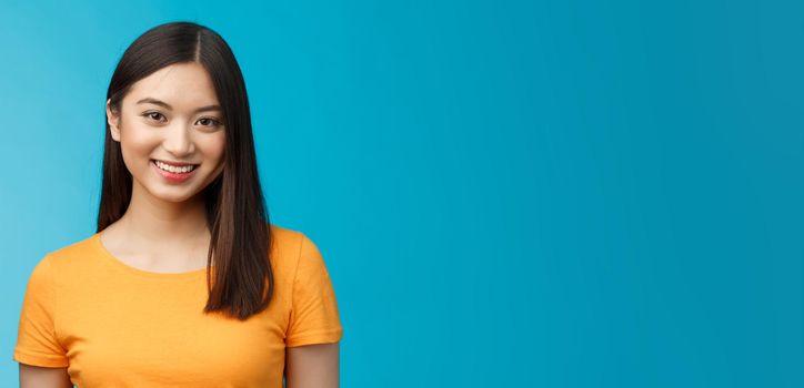 Close-up charming attractive asian girl pure clean skin condition, smiling joyfully look camera upbeat, politely listen, express positive good mood motivated achieve success, stand blue background.