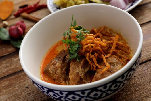 Local northern Thai food Egg noodle curry with pork ribs on wood background