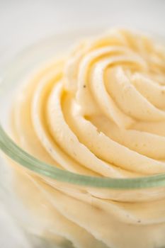 Swirl of eggnog buttercream frosting in a small glass bowl.