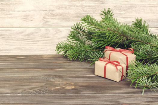 Toned Christmas background with Christmas gift on wooden background with Fir branches. Xmas and Happy New Year composition. Flat lay, top view.