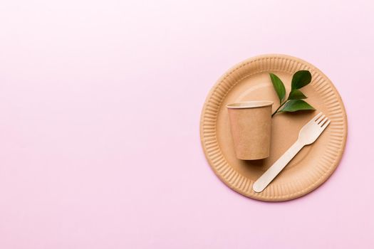 set of empty reusable disposable eco-friendly plates, cups, utensils on light white colored table background. top view. Biodegradable craft dishes. Recycling concept. Close-up.