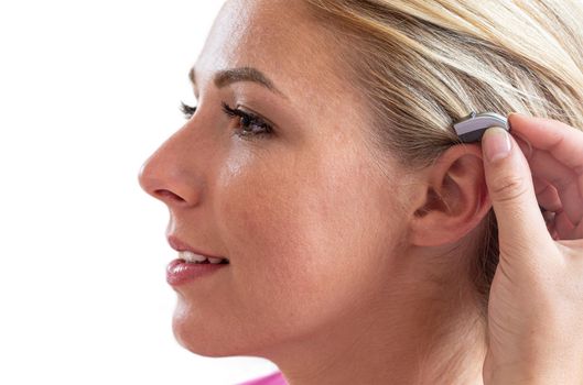 Woman in front of a hearing care professional to test a hearing aid.