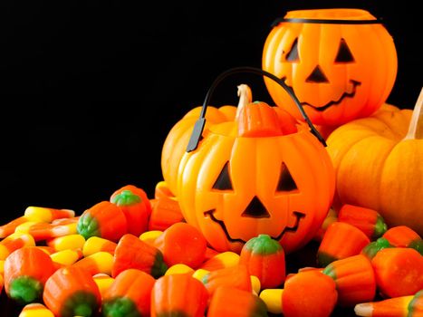 Halloween candies spilled on black background.